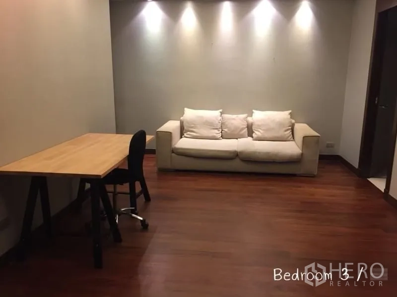 คอนโด ให้เช่าในSathon, Bangkok - ห้องอเนกประสงค์มีโต๊ะไม้และโซฟาสีครีม ผนังติดไฟสปอตไลท์