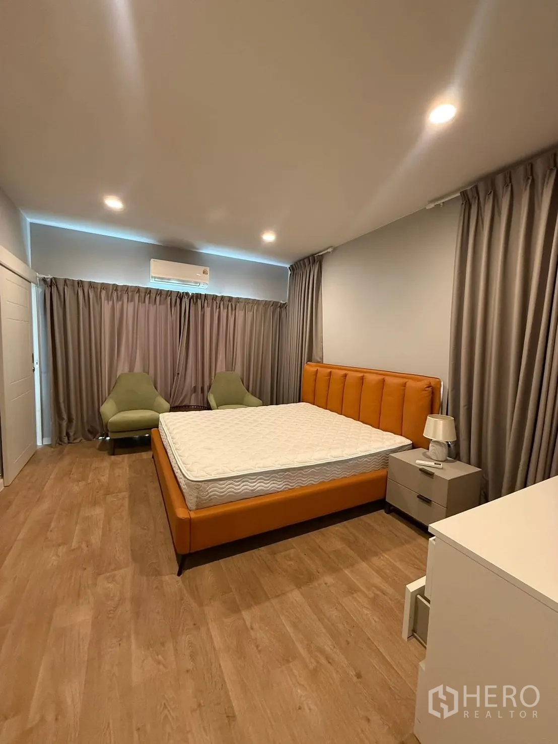 独栋房屋 for rent in Bang Kapi, Bangkok - 宽敞卧室，橙色软包床，木地板，灰色窗帘与筒灯。