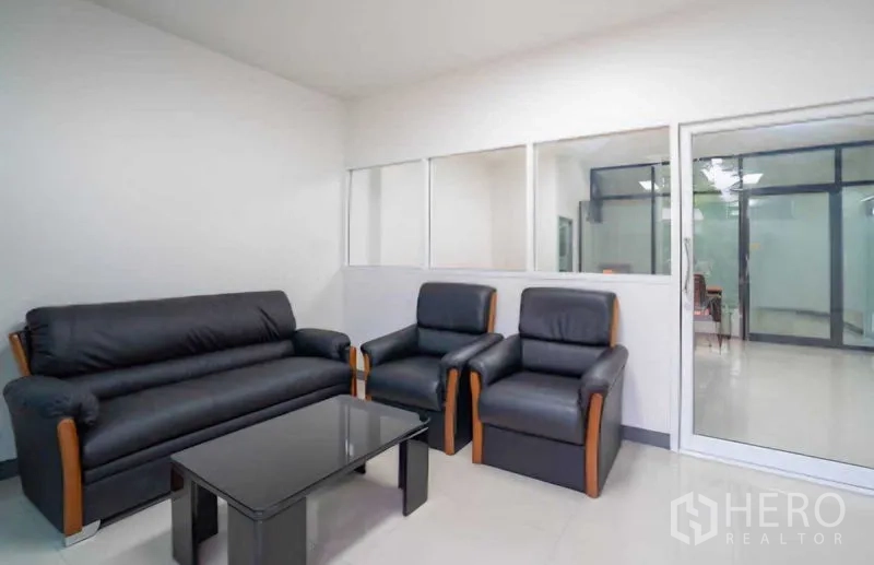 Home Office for rent or sale in Lat Krabang, Bangkok - Reception lounge with black leather sofa set and glass coffee table.
