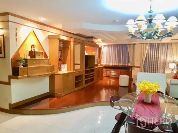 公寓 出租在Watthana, Bangkok - 温馨客厅，带木质一体化电视柜、玻璃餐桌与吊灯照明。