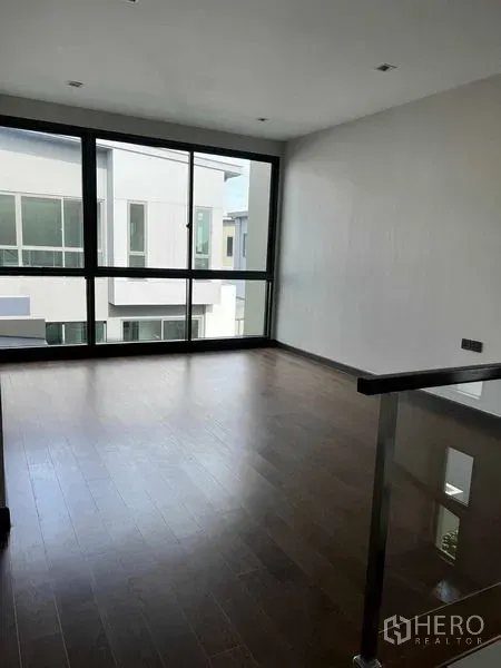 Detached House for sale in Bang Kruai, Nonthaburi - Bright upper living area with wide windows and wood flooring.