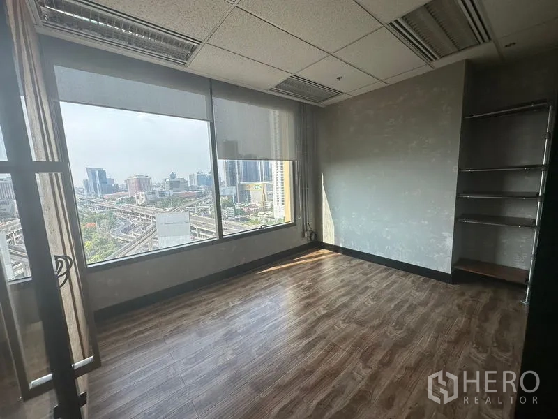 Office Space for rent in Chatuchak, Bangkok - Bright corner office with wood floors, large windows, and a wide skyline view over Chatuchak.