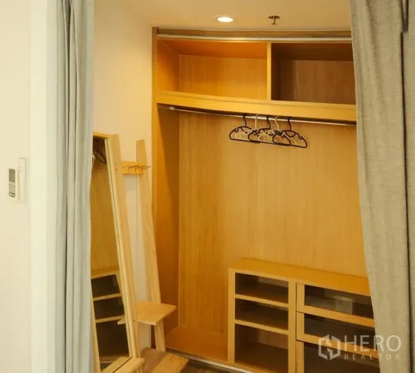 Condominium for rent in Bang Rak, Bangkok - Built-in wooden walk-in closet with shelves, hanging rail and mirror.