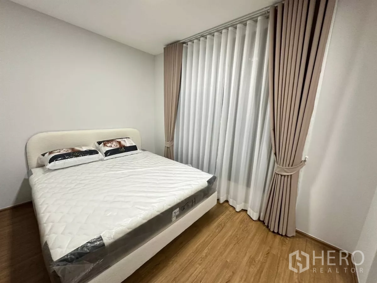 Townhouse for rent in Bang Phli, Samut Prakan - Primary bedroom from another angle showing the large window with sheer and blackout drapes.