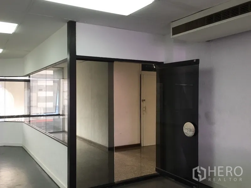 สำนักงานที่บ้าน ให้เช่าในHuai Khwang, Bangkok - โถงภายในพร้อมประตูกระจกสีดำและห้องประชุมกั้นกระจก.