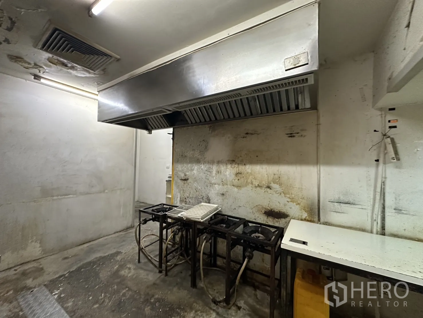 Retail Space for rent in Watthana, Bangkok - Cooking area with large stainless ventilation hood and gas stoves.
