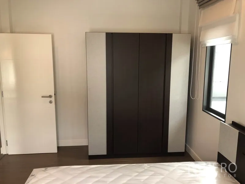 Detached House for rent or sale in Bang Kapi, Bangkok - Bedroom corner with large freestanding wardrobe beside windows.