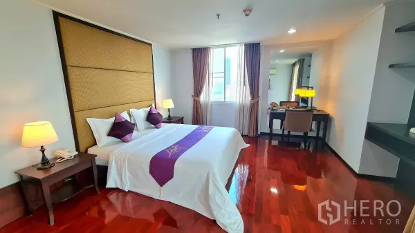 房间 出租在Watthana, Bangkok - 宽敞主卧，配特大床、特色床头板、书桌与木地板