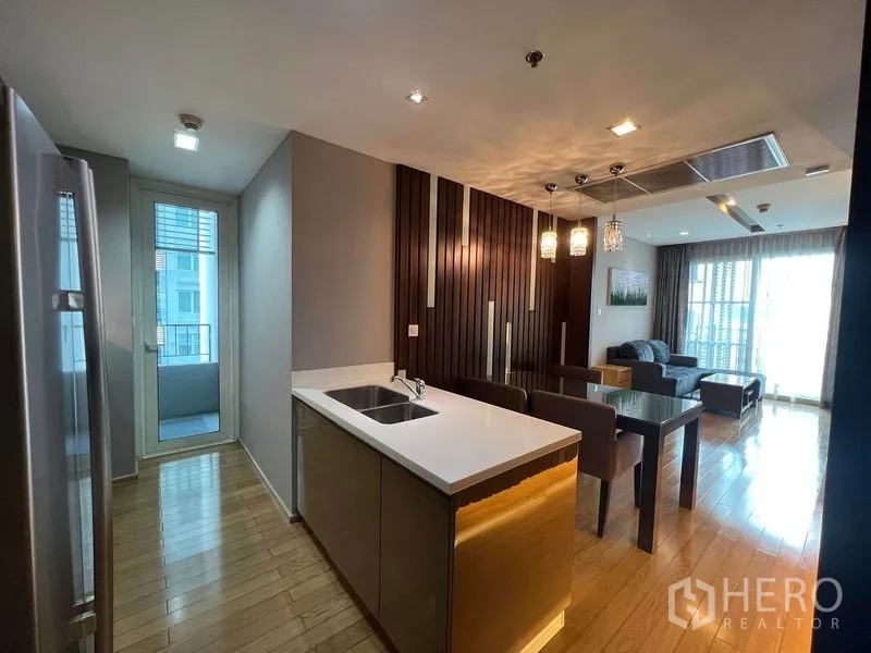 公寓 出租在Khlong Toei, Bangkok - 开放式厨房带中岛与水槽，连接餐厅与客厅，并通向阳台。