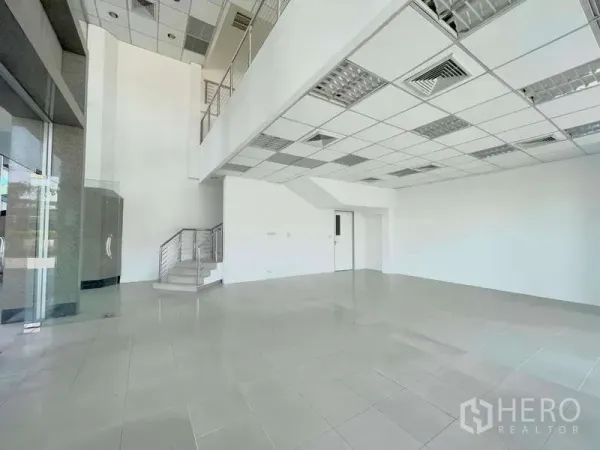 Retail Space for rent in Yan Nawa, Bangkok - Bright double-height retail interior with mezzanine, tiled floors and a staircase.