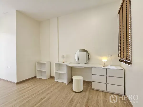 Townhouse for sale in Lat Phrao, Bangkok - Bright multipurpose room with built-in white vanity, shelves and warm wood flooring.