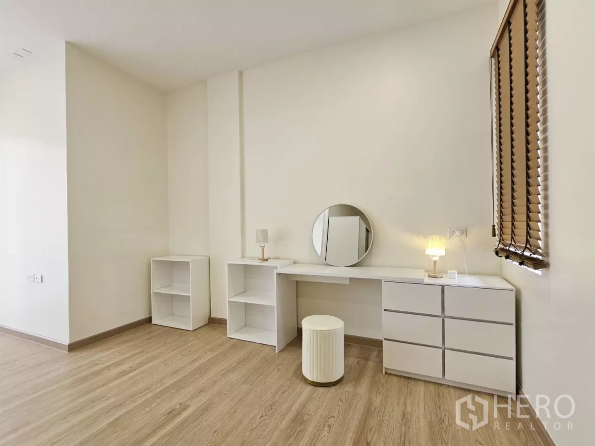 Townhouse for sale in Lat Phrao, Bangkok - Bright multipurpose room with built-in white vanity, shelves and warm wood flooring.