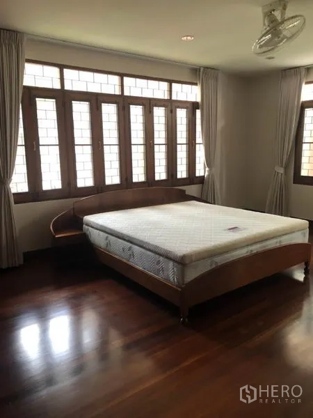 บ้าน ให้เช่าในWatthana, Bangkok - ห้องนอนพร้อมหน้าต่างบานใหญ่ ผ้าม่าน และเตียงบนพื้นไม้