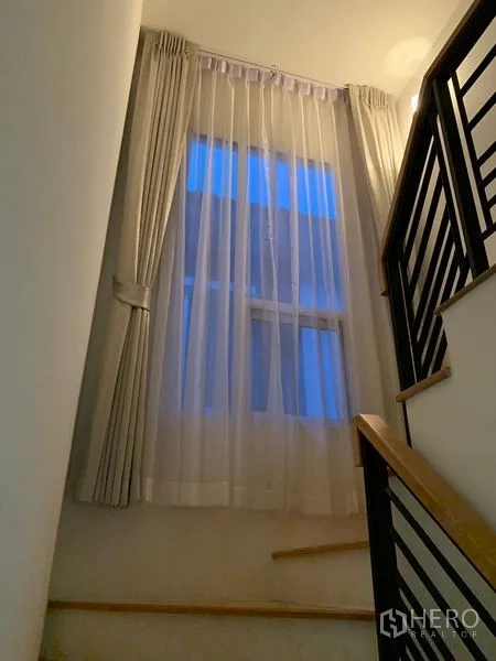 บ้าน ขายในPrawet, Bangkok - บันไดพร้อมราวเหล็กและหน้าต่างสูงติดผ้าม่านโปร่ง
