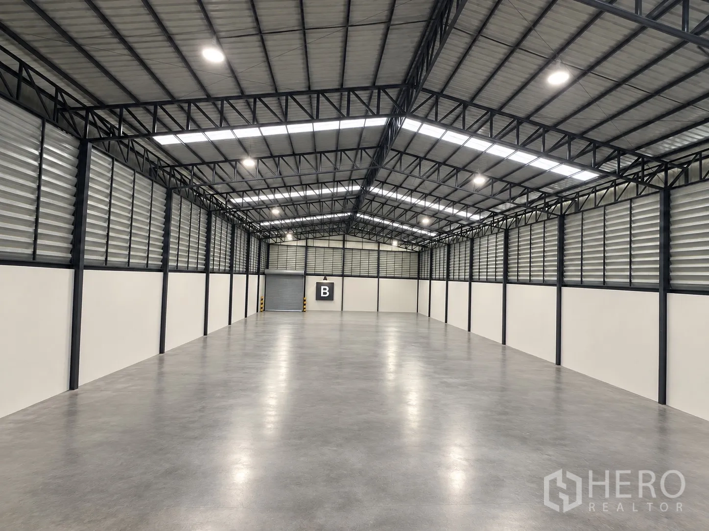 โรงงาน for rent in Mueang Samut Sakhon, Samut Sakhon - ภายในคลังสินค้าพื้นคอนกรีตขัดเงา หลังคาโครงเหล็กสูง มีสกายไลท์ บานเกล็ดระบายอากาศ และประตูม้วน B