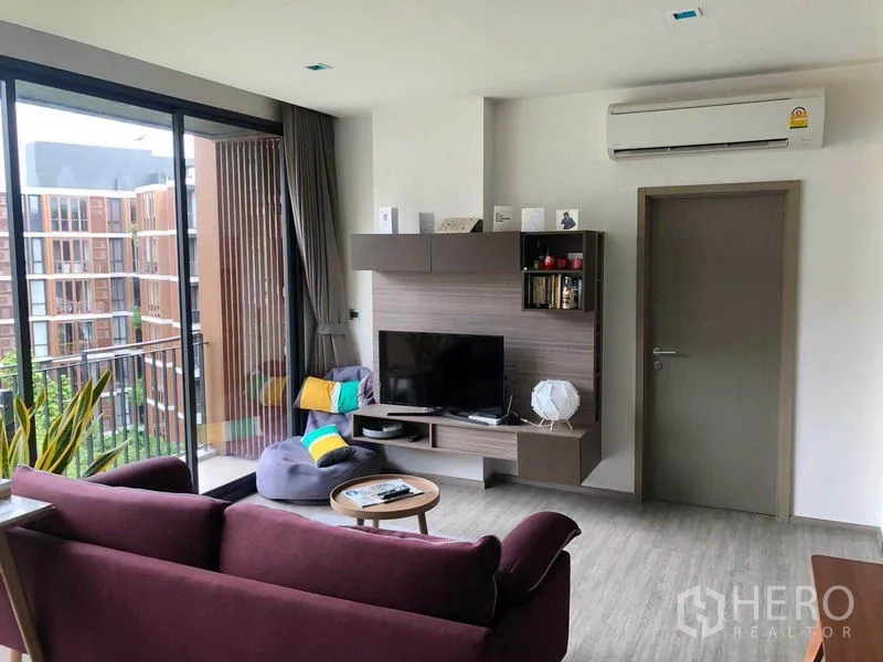 公寓 出租在Watthana, Bangkok - 客厅电视墙与阳台相邻，可见花园景。