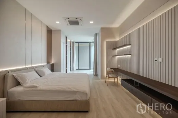 Detached House for rent in Saphan Sung, Bangkok - Spacious master bedroom with feature wall, built-in desk and soft cove lighting.