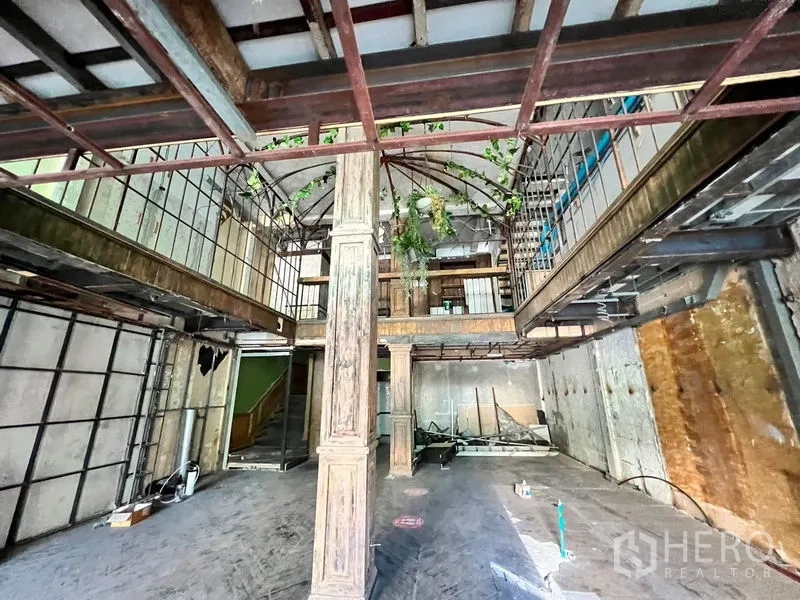 Shophouse for rent in Watthana, Bangkok - Central atrium framed by columns, exposed beams, and metal trusses ready for fit-out.