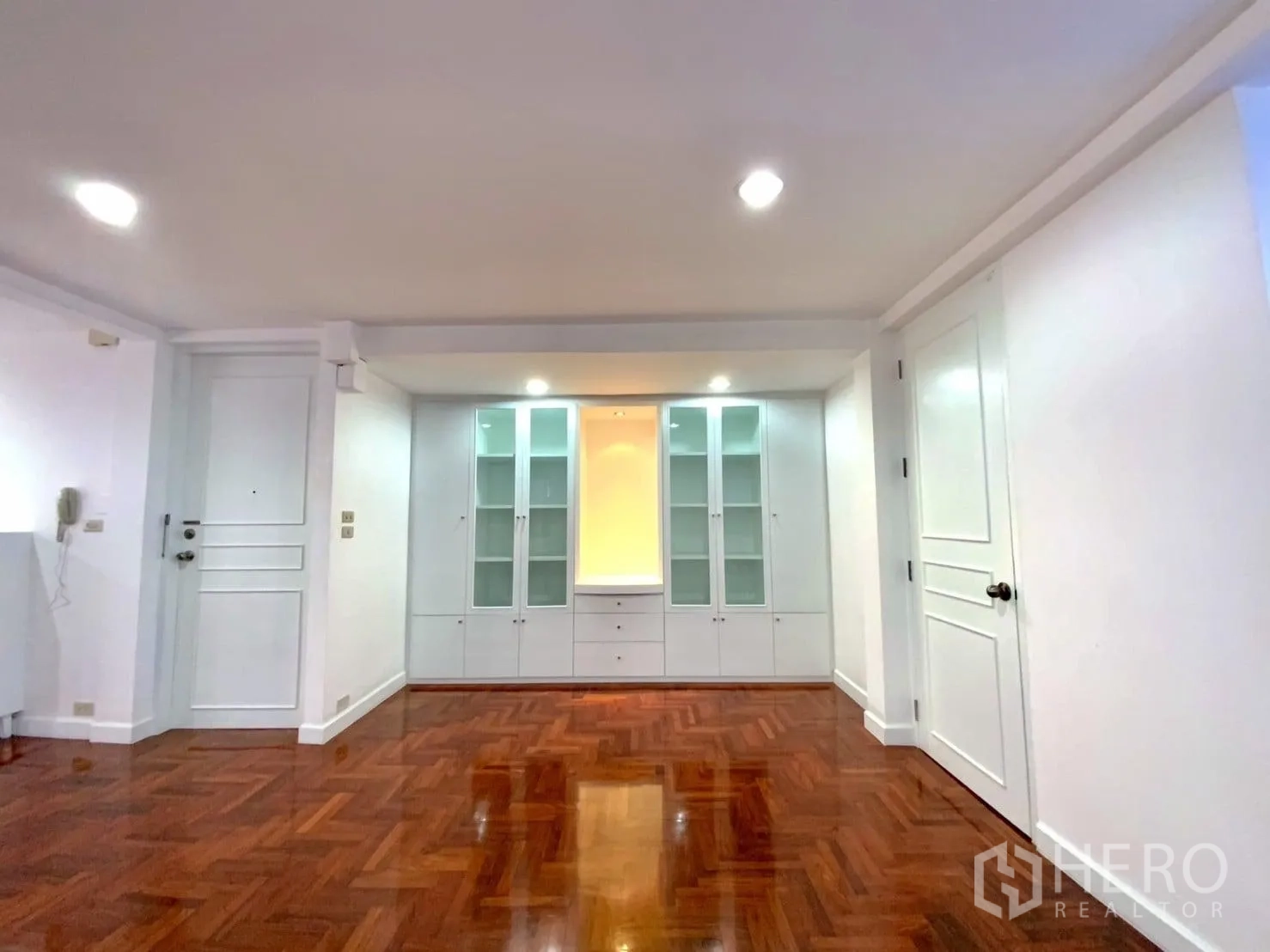 公寓 出租在Watthana, Bangkok - 入户走廊带玻璃展示柜，嵌灯与亮泽木地板。
