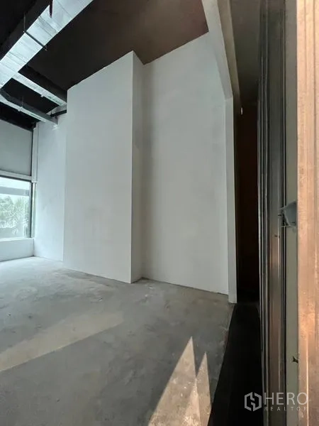 零售空间 出租 - 商铺后部角落，设备墙与高天花，待装修