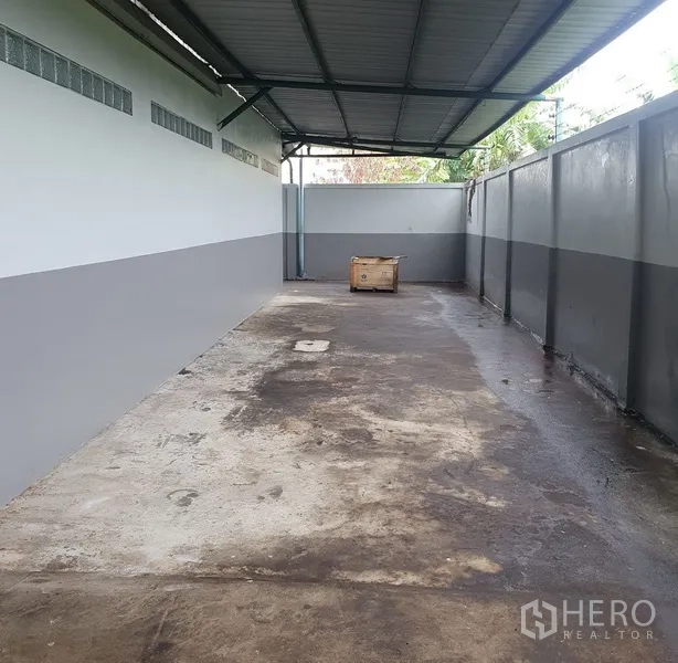 工厂 出租在Saphan Sung, Bangkok - 带顶侧院，混凝土地面与高墙，适合装卸或临时存放。