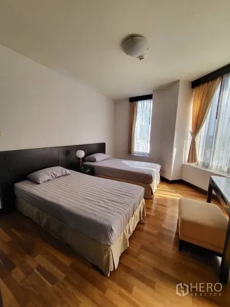 公寓 出租或出售在Pathum Wan, Bangkok - 来客卧配两张单人床、床头柜与高窗，木地板明亮整洁。