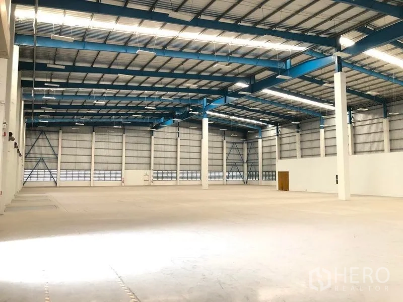 Warehouse for rent in Bang Phli, Samut Prakan - Open-plan warehouse floor with high roof and bright linear lighting for logistics operations.