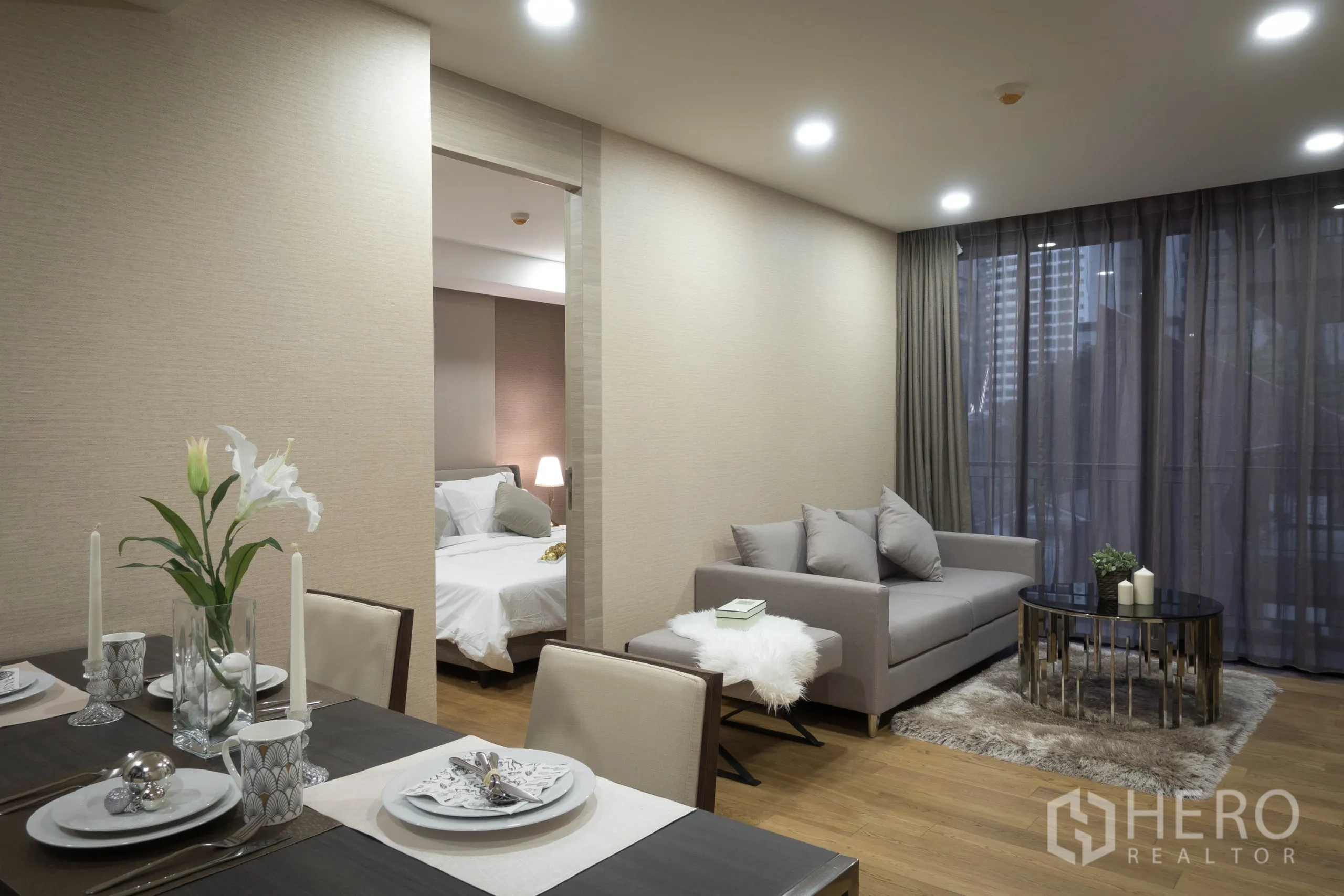 คอนโด ให้เช่าในPathum Wan, Bangkok - ห้องนั่งเล่นถัดจากโต๊ะอาหาร มองเห็นทางเข้าห้องนอนผ่านประตูบานเลื่อน.