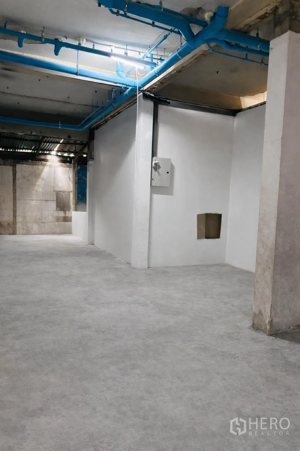 零售空间 for rent in Watthana, Bangkok - 深进深的开放式铺面，白色隔墙、水泥地面与天花管线清晰可见。