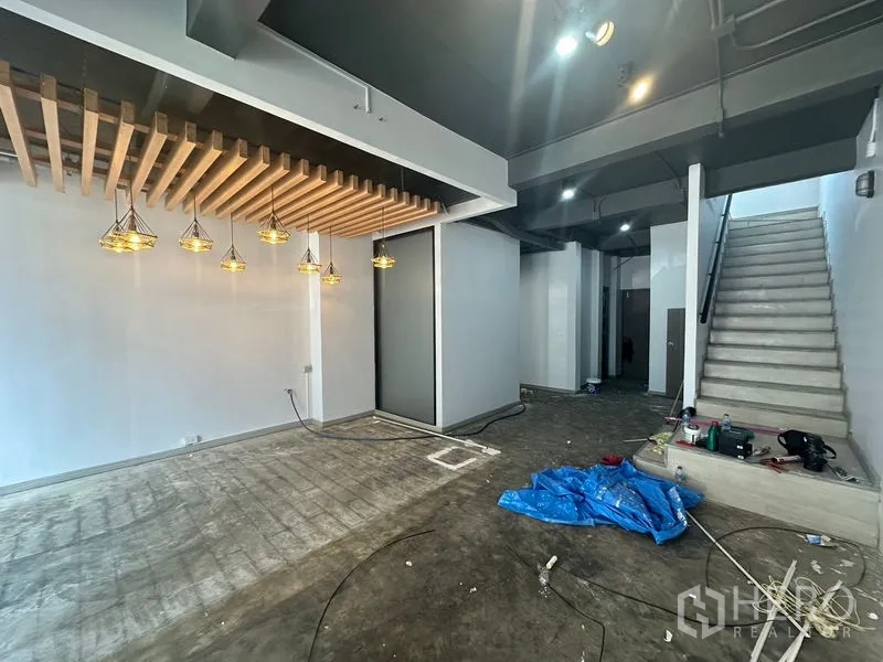 带办公室的家 出租 - 一层工作区装修中，木格栅天花与楼梯。