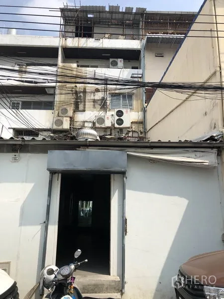 带办公室的家 出租或出售在Huai Khwang, Bangkok - 建筑后立面，服务入口、多台空调外机与上方线路。