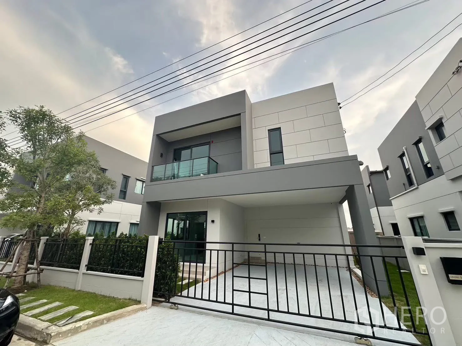Detached House for rent in Bang Phli, Samut Prakan - Modern two-storey house exterior with gate, carport and balcony.