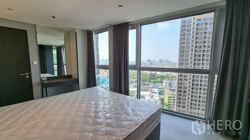公寓 出售在Watthana, Bangkok - 卧室转角大幅玻璃，呈现全景城市天际线。