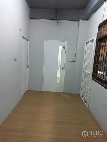 Shophouse for rent in Khlong Toei, Bangkok - Hallway with light wood floor and multiple white doors to private rooms.
