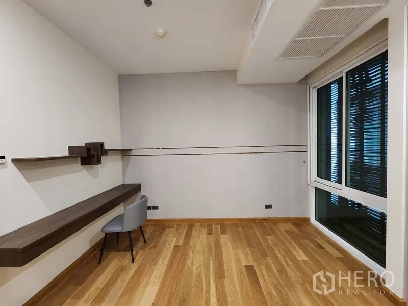 Condominium for rent in Khlong Toei, Bangkok - Multipurpose room with long floating desk and corner window.