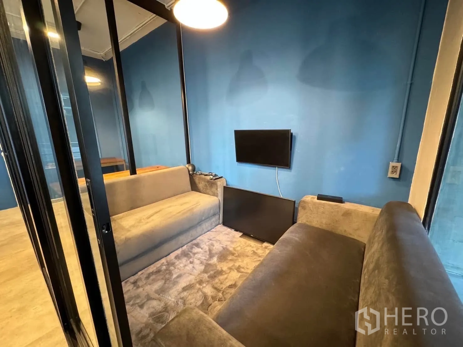 โฮมออฟฟิศ for rent in Watthana, Bangkok - บูธประชุมส่วนตัวพร้อมโซฟาสองตัวและทีวี ติดผนังอยู่หลังประตูกระจก