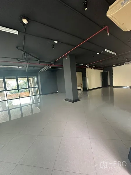 办公空间 出租在Khlong Toei, Bangkok - 宽敞办公室，黑色外露顶与瓷砖地面，多处玻璃门。
