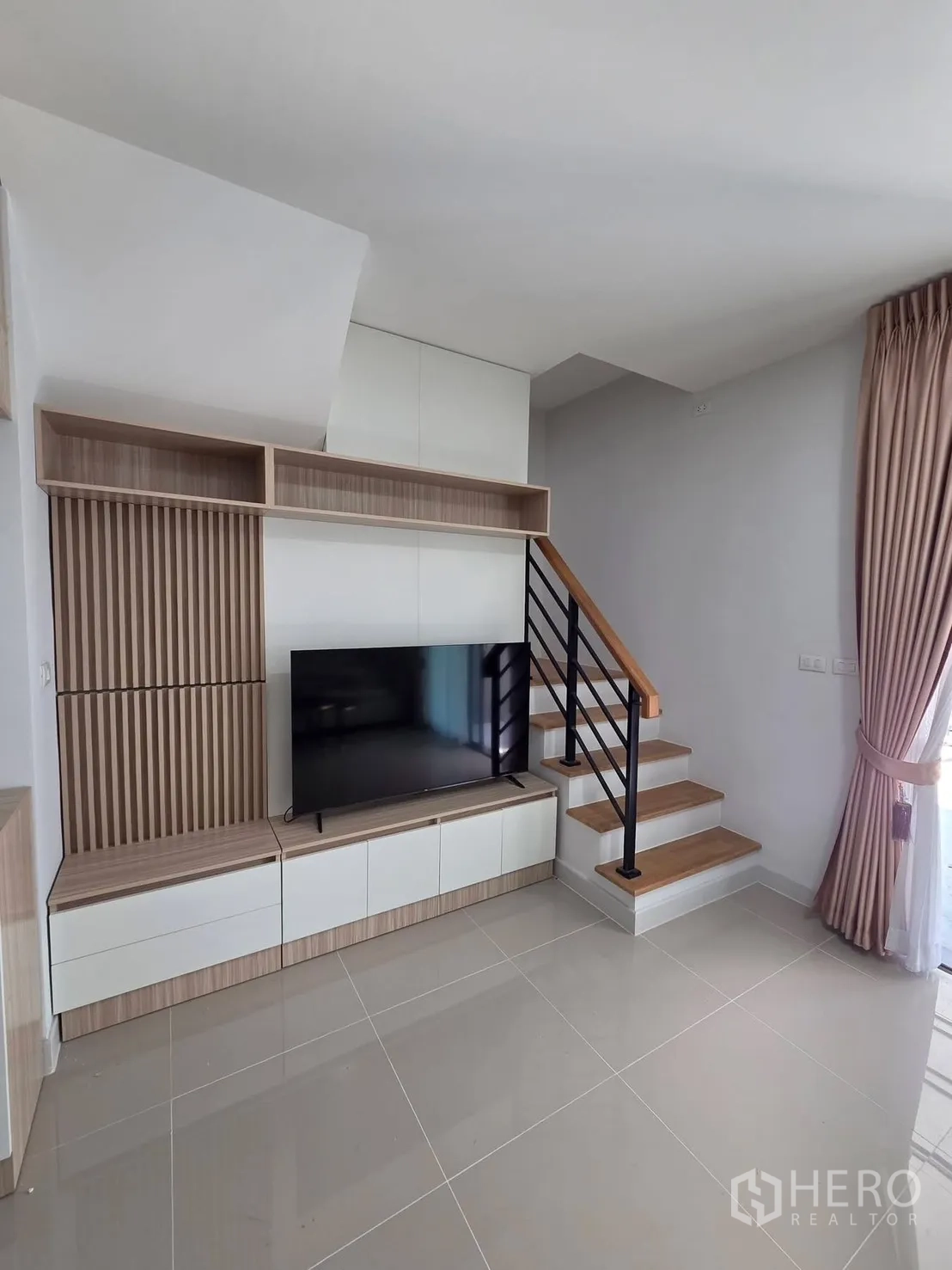 ทาวน์เฮาส์ for rent in Bang Phli, Samut Prakan - ชั้นวางทีวีลายไม้ข้างบันไดขั้นไม้ราวสีดำ