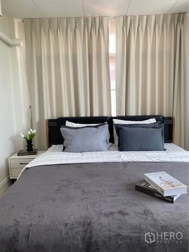 บ้านเดี่ยว for rent in Huai Khwang, Bangkok - ห้องนอนอบอุ่นมีเตียง โต๊ะข้างเตียง และผ้าม่านทึบยาว