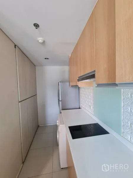 公寓 出售在Ratchathewi, Bangkok - 走廊式厨房，白色台面、木柜、电磁炉、冰箱与洗衣机