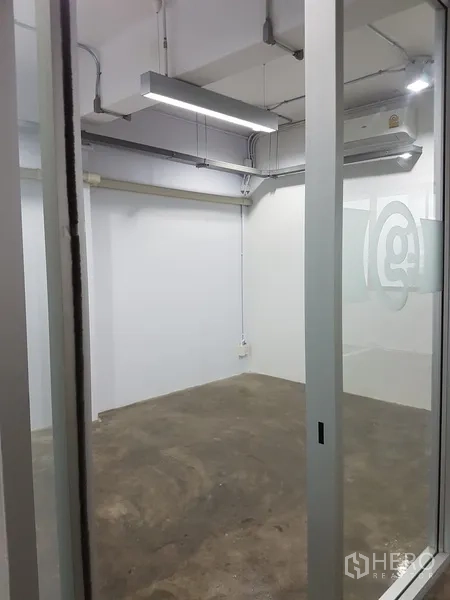 Home Office for sale in Khlong Toei, Bangkok - Twin restrooms with purple door frames and concrete walls.