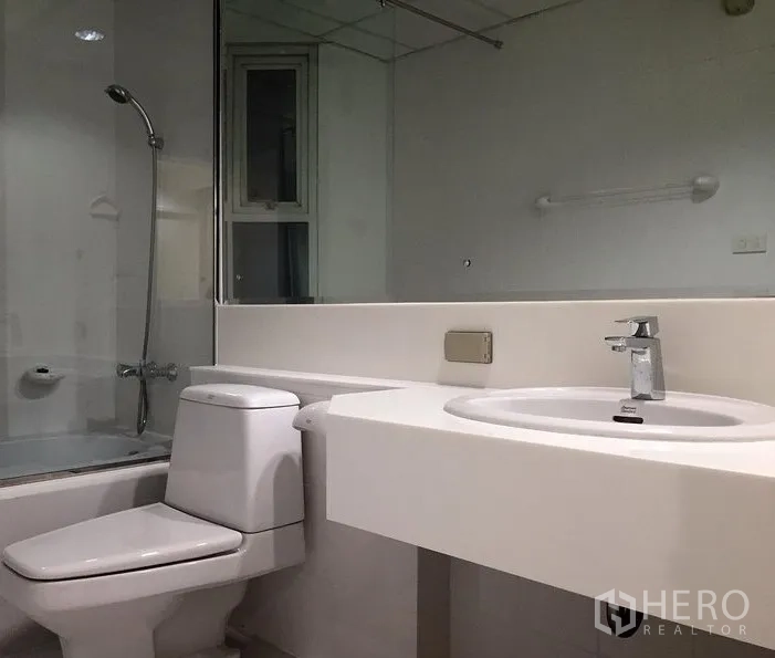 公寓 出租在Bang Rak, Bangkok - 现代浴室，浴缸带淋浴、大镜面、马桶与洗手台。