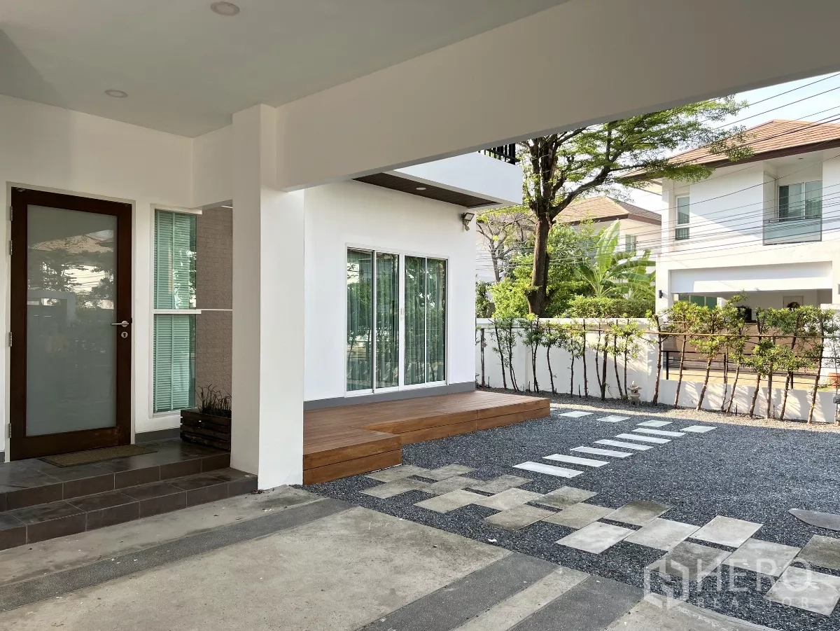 独立式住宅 出租或出售在Saphan Sung, Bangkok - 有顶车位及主入口，旁为木平台与推拉门。