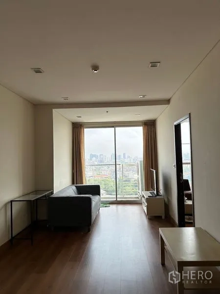 公寓 出售在Watthana, Bangkok - 开放式客餐区，通向阳台，木地板与沙发。