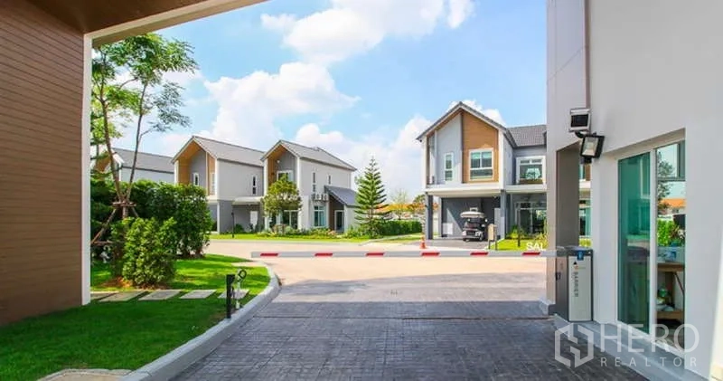 Detached House for sale in Lam Luk Ka, Pathum Thani - Internal estate road lined with modern homes and green spaces.