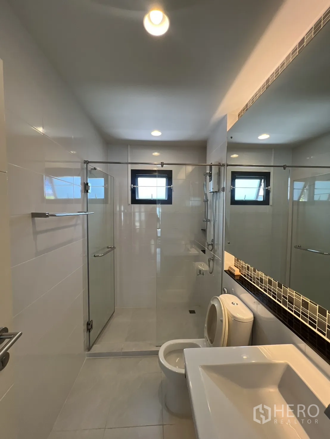 Detached House for sale in Bang Kapi, Bangkok - Large master bedroom with TV wall, curtains, and wood flooring.