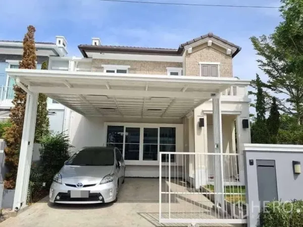 Detached House for rent in Prawet, Bangkok - Street-facing facade of the detached house with white carport and gate.