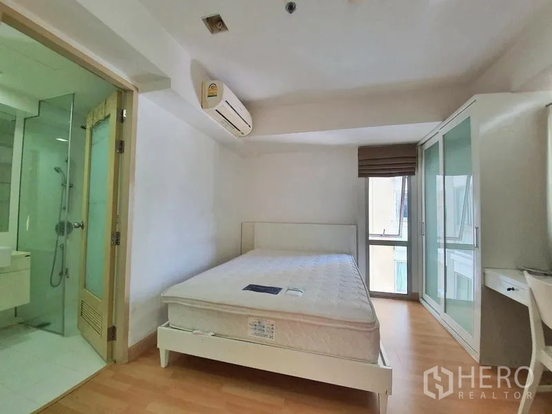 Condominium for rent in Din Daeng, Bangkok - Air-conditioned bedroom with a queen bed, sliding glass wardrobe, and ensuite bathroom access.