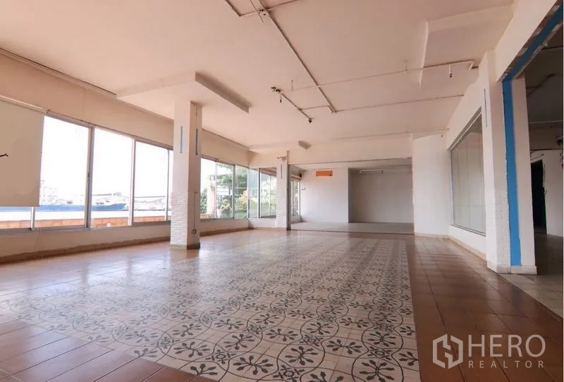 Retail Space for rent in Yan Nawa, Bangkok - Bright showroom area featuring patterned central tiling and wraparound glazing.