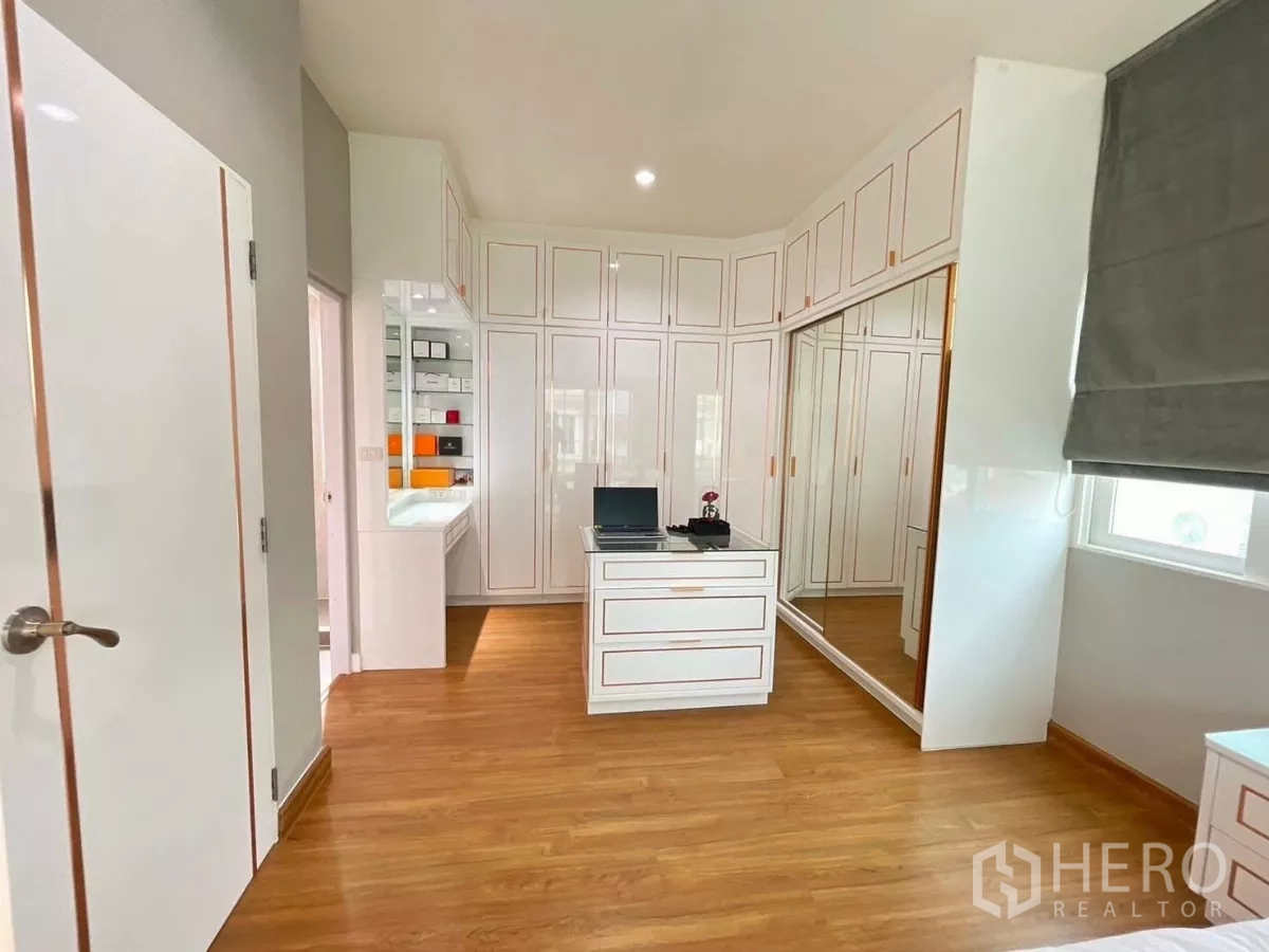 Detached House for rent in Bang Khen, Bangkok - Walk‑in dressing room with extensive built‑in wardrobes, vanity and wood flooring.